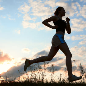 Silhouette woman run under blue sky with clouds and sun