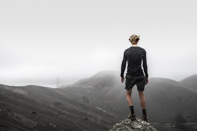 Man overlooking mountain in running attire
