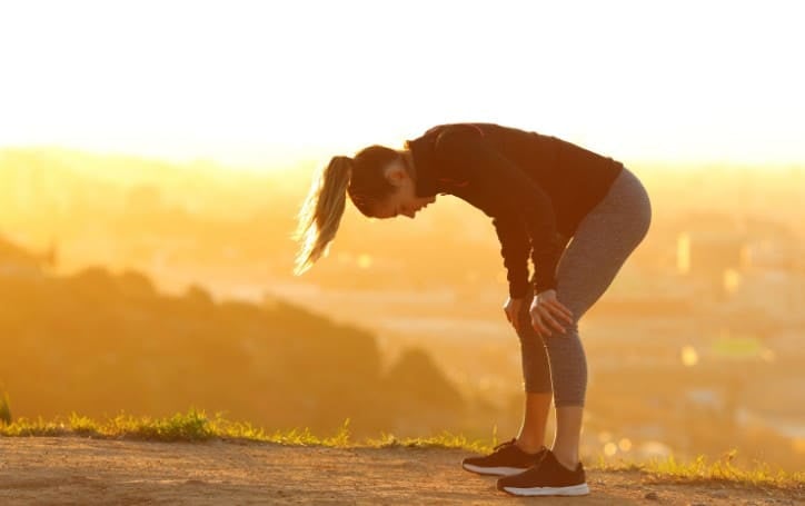 Runner bent over exhausted trying to carry on