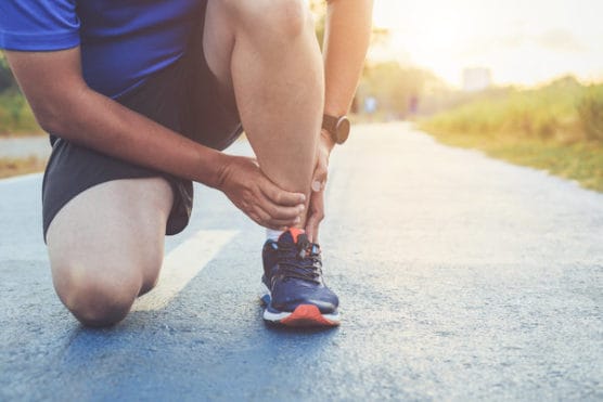 Injured runner holding his ankle 