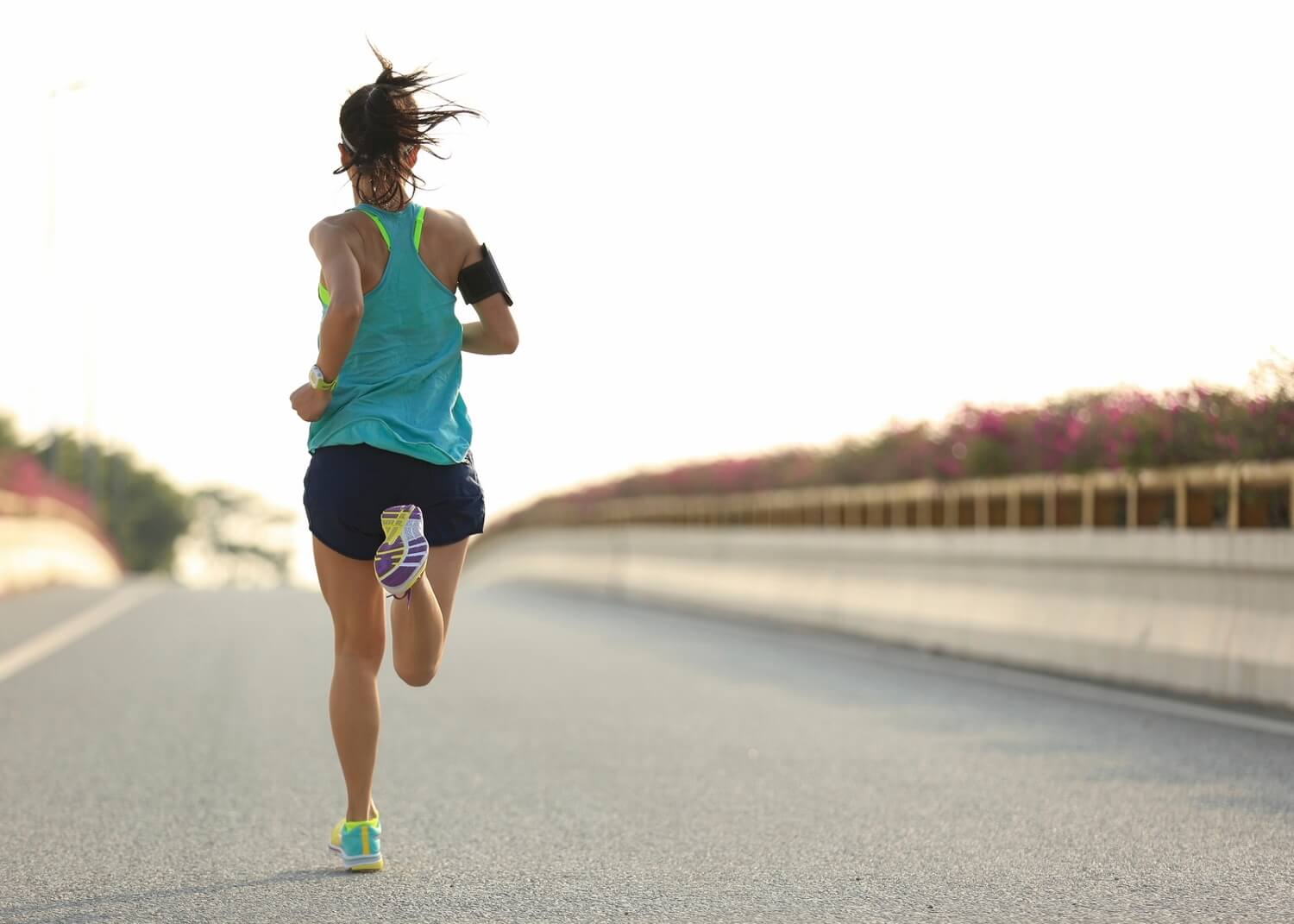 Woman running on the road from behind