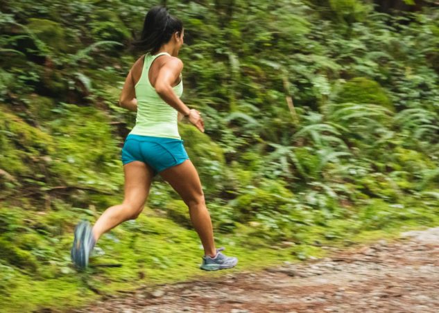Female runner from behind running in the trails