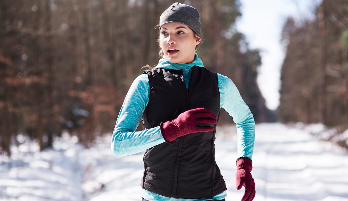 Woman running in the winter with running gloves on