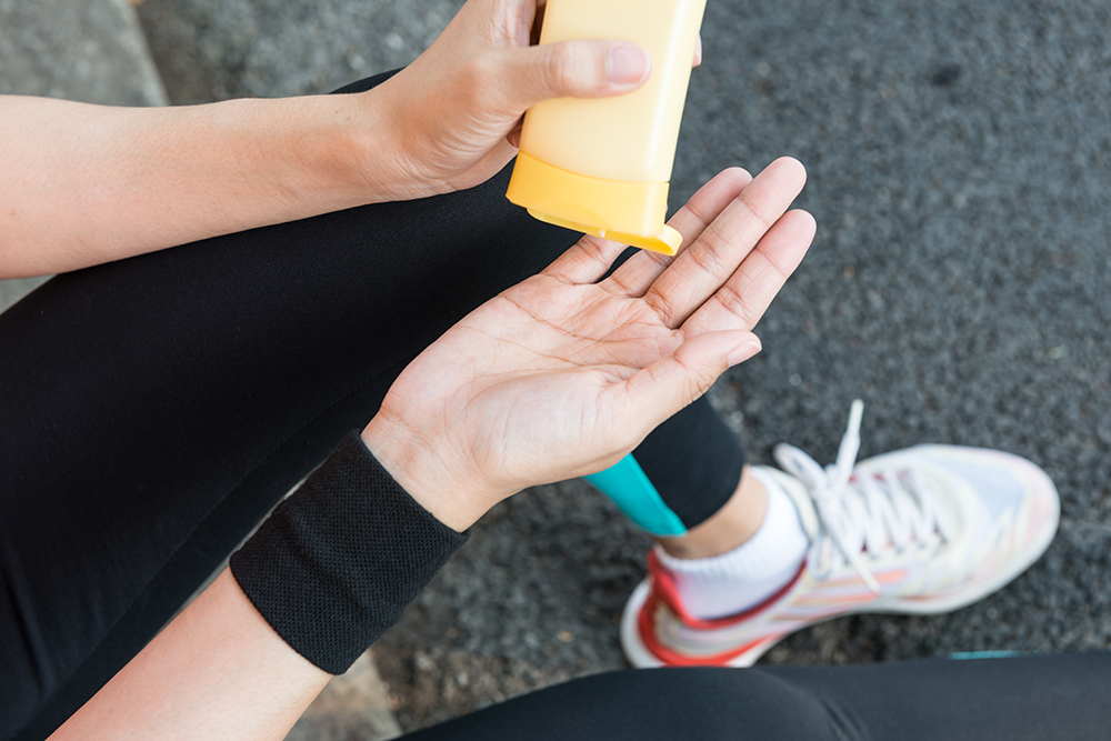 Runner applying sunscreen