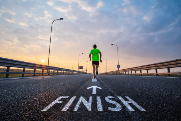 Runner across the finish line, the word painted on the floor